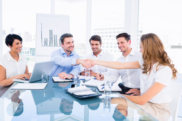 Smartly dressed executives shaking hands during a business meeti