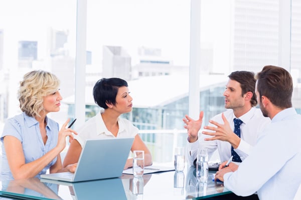 Smartly dressed young executives sitting around conference table