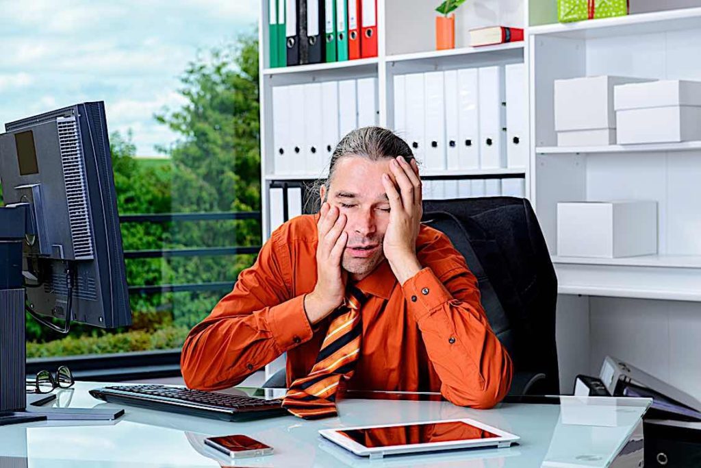 Over worked business man at desk Pivotal HR Solutions Blog