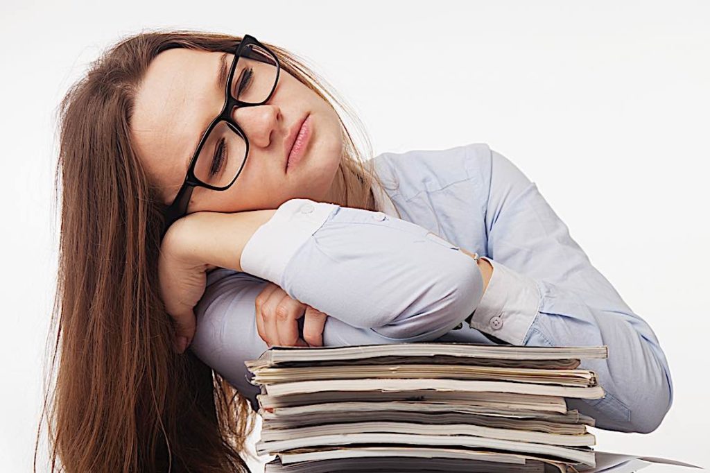 Overworked sleeping on pile of work Pivotal HR Solutions Blog