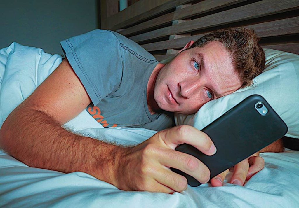 Seven Digital Detox methods that can increase office productivity; human office workers now have an average attention span of 8 seconds, less than a goldfish 3 Phone in bed shows addiction digital Pivotal HR Solutions Blog
