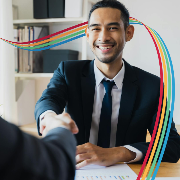 Man in suit shaking hands and smiling.