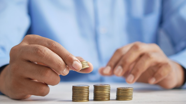 A person stacking coins on a table