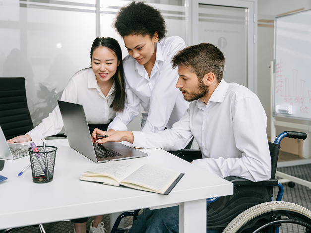 Coworkers looking at laptop in office