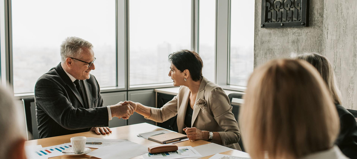Man and woman shaking hands in meeting