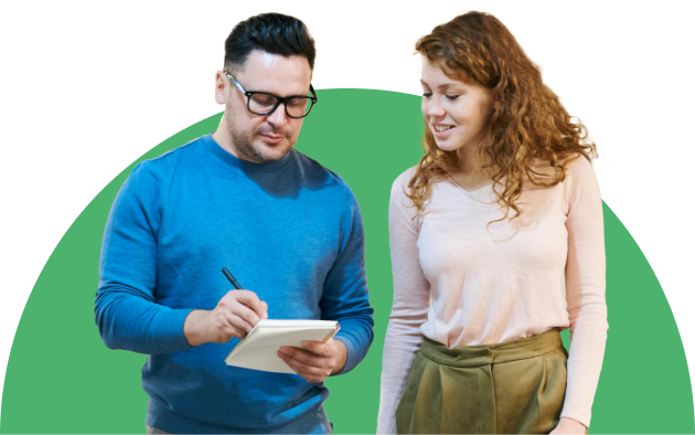 Man and woman walking while looking at notebook