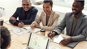 Photo of Three People Smiling While Having a Meeting