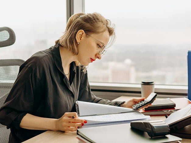 Woman in black shirt using calculator