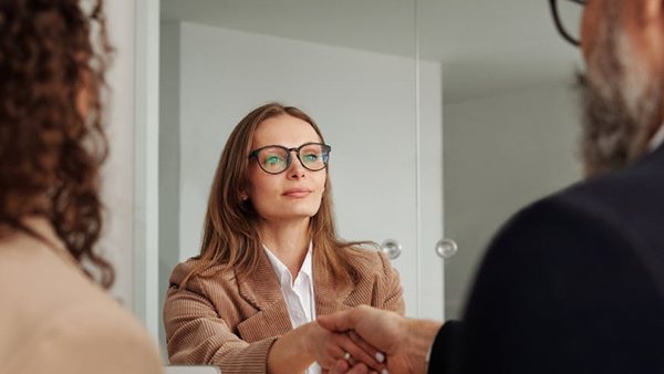 Woman in glasses shaking a man's hand