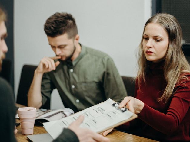 Woman handing man a resume